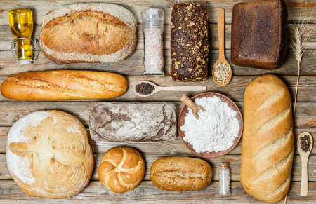 Gluten-free fresh bread of different colors and shapes on wooden surfaceの写真素材