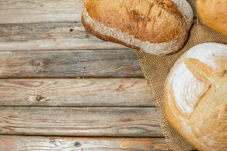 Gluten-free fresh bread of different colors and shapes on wooden surfaceの写真素材