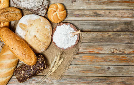 Gluten-free fresh bread of different colors and shapes on wooden surfaceの写真素材