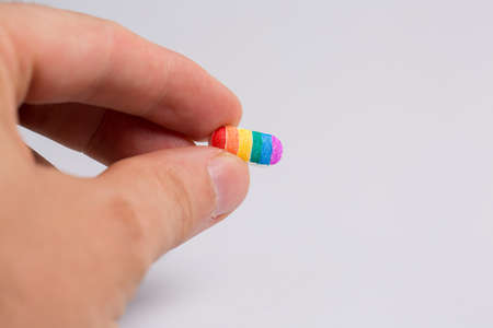 Tablet with lgbt flowers in hand, rainbow, on white background