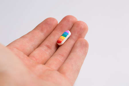 Tablet with lgbt flowers in hand, rainbow, on white backgroundの写真素材