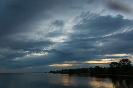 Beautiful orange sunset by the river bankの写真素材