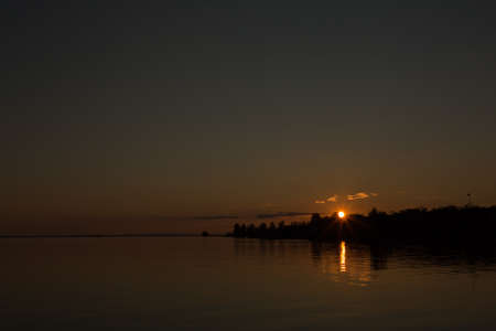 Beautiful orange sunset by the river bankの写真素材