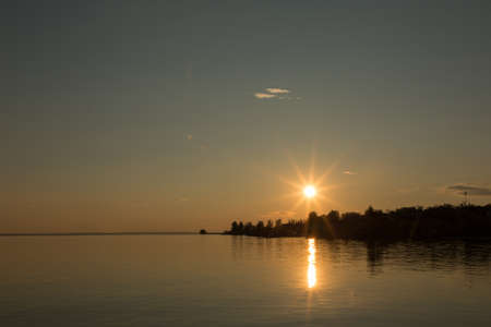 Beautiful orange sunset by the river bankの写真素材