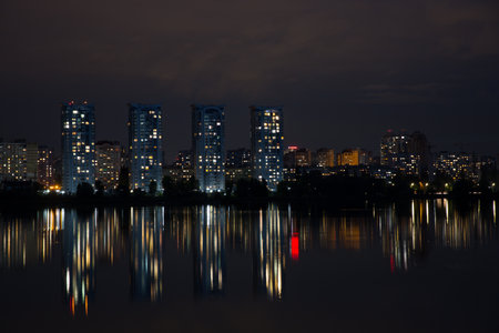 Multi-storey buildings of a big city near the river at nightの写真素材