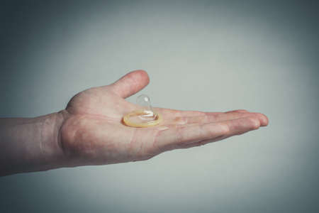 Safe sex condom in man's hand, contraceptiveの写真素材