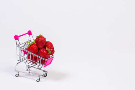 Strawberries in a grocery trolley on a white backgroundの写真素材