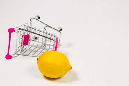 Lemon in a grocery trolley on a white backgroundの写真素材