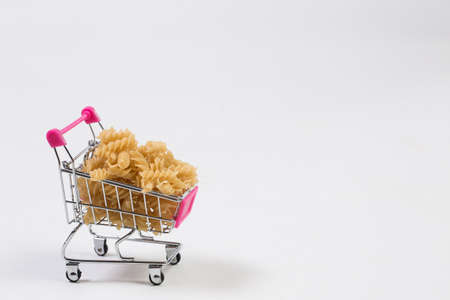 Pasta in a shopping basket on a white backgroundの写真素材