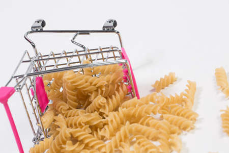 Pasta in a shopping basket on a white backgroundの写真素材