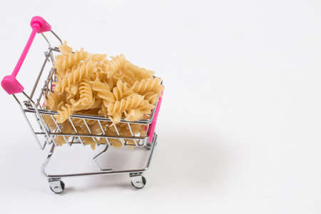 Pasta in a shopping basket on a white backgroundの写真素材