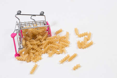 Pasta in a shopping basket on a white backgroundの写真素材