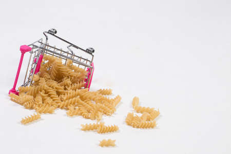 Pasta in a shopping basket on a white backgroundの写真素材