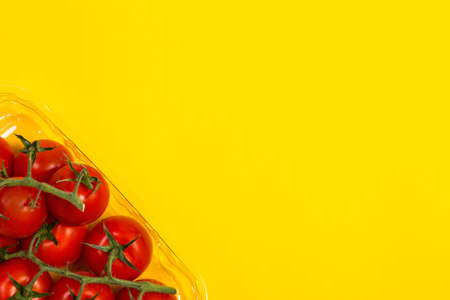 Red cherry tomatoes for salad on yellow backgroundの写真素材