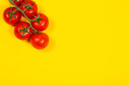 Red cherry tomatoes for salad on yellow backgroundの写真素材