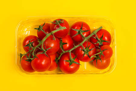 Red cherry tomatoes for salad on yellow backgroundの写真素材