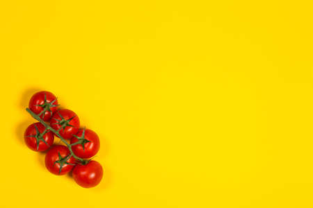 Red cherry tomatoes for salad on yellow backgroundの写真素材
