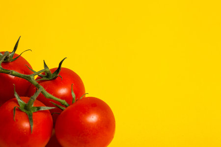 Red cherry tomatoes for salad on yellow backgroundの写真素材