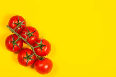 Red cherry tomatoes for salad on yellow backgroundの写真素材