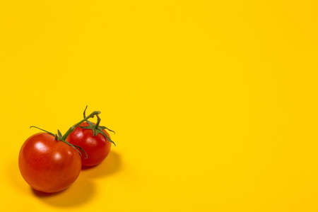 Red cherry tomatoes for salad on yellow backgroundの写真素材