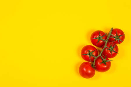 Red cherry tomatoes for salad on yellow backgroundの写真素材