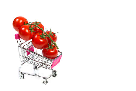 Cherry tomatoes and shopping cart on white backgroundの写真素材