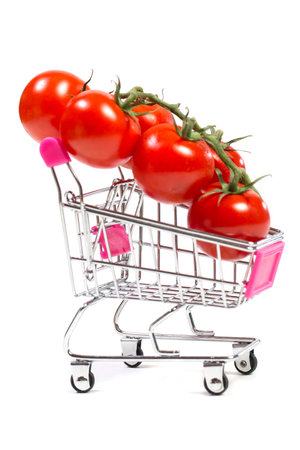 Cherry tomatoes and shopping cart on white backgroundの写真素材