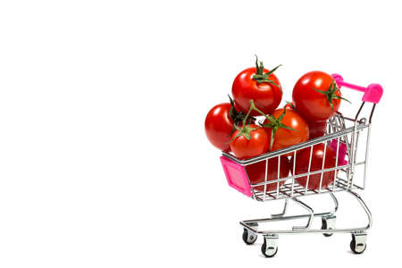 Cherry tomatoes and shopping cart on white backgroundの写真素材