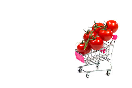 Cherry tomatoes and shopping cart on white backgroundの写真素材