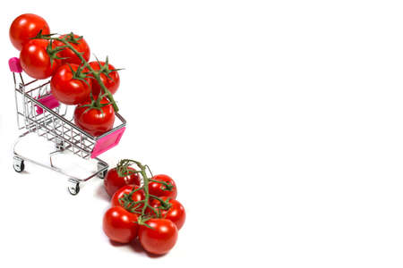 Cherry tomatoes and shopping cart on white backgroundの写真素材