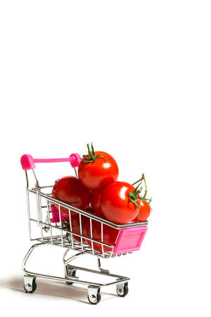 Cherry tomatoes and shopping cart on white backgroundの写真素材