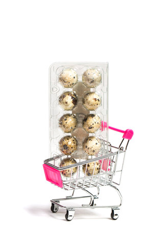 Small quail eggs in a shopping trolley on a white background, healthy foodの写真素材