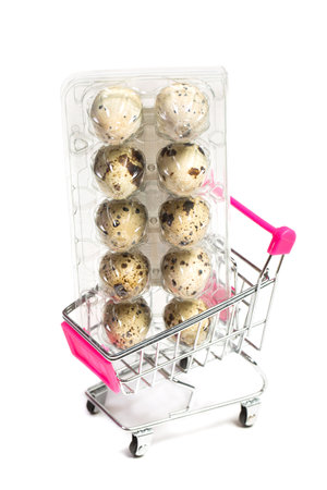 Small quail eggs in a shopping trolley on a white background, healthy foodの写真素材