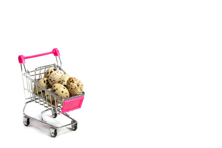 Small quail eggs in a shopping trolley on a white background, healthy foodの写真素材