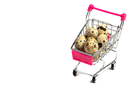 Small quail eggs in a shopping trolley on a white background, healthy foodの写真素材