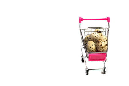 Small quail eggs in a shopping trolley on a white background, healthy foodの写真素材