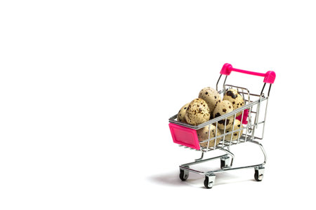 Small quail eggs in a shopping trolley on a white background, healthy foodの写真素材