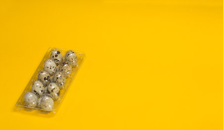 Small quail eggs on a yellow background, healthy foodの写真素材