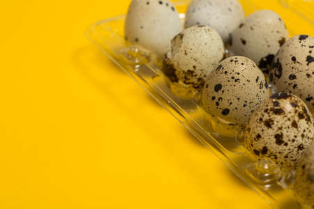 Small quail eggs on a yellow background, healthy foodの写真素材