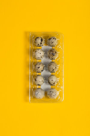 Small quail eggs on a yellow background, healthy foodの写真素材