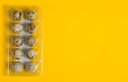 Small quail eggs on a yellow background, healthy foodの写真素材