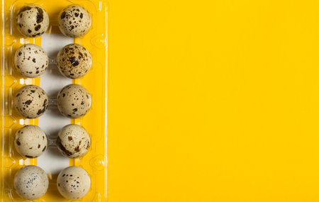 Small quail eggs on a yellow background, healthy foodの写真素材