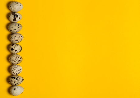 Small quail eggs on a yellow background, healthy foodの写真素材
