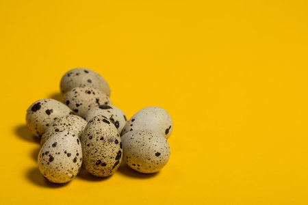 Small quail eggs on a yellow background, healthy foodの写真素材
