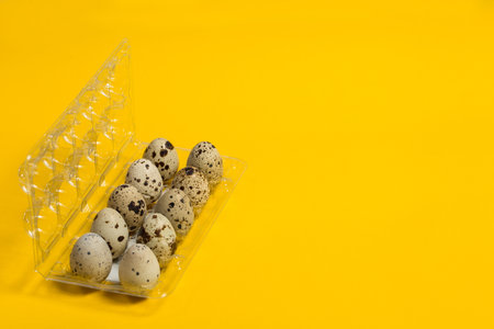 Small quail eggs on a yellow background, healthy foodの写真素材