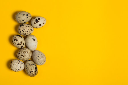 Small quail eggs on a yellow background, healthy foodの写真素材