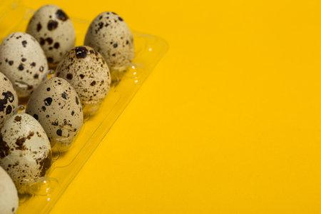 Small quail eggs on a yellow background, healthy foodの写真素材