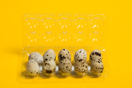 Small quail eggs on a yellow background, healthy foodの写真素材