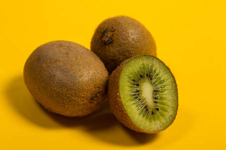 Fresh and tasty kiwi fruit on a yellow backgroundの写真素材