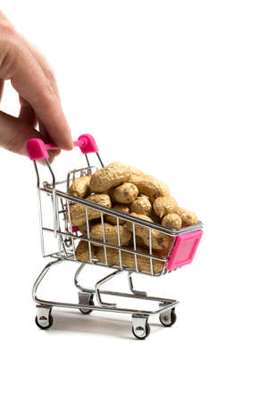 Peanuts in a shell in a shopping cart on a white background, healthy foodの写真素材